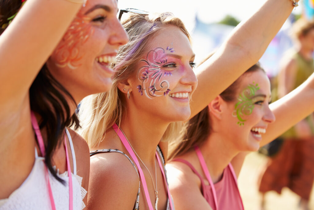 Three girl friends at a music festival, side view